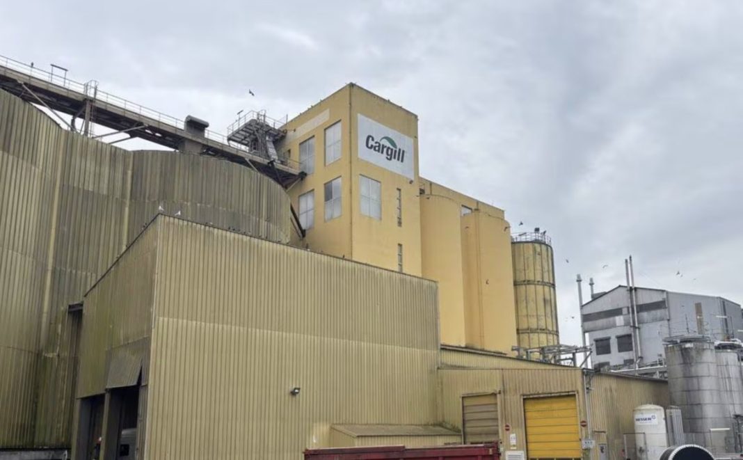 Industrial grain facility with beige/yellow buildings and a visible 'Cargill' sign on the facade