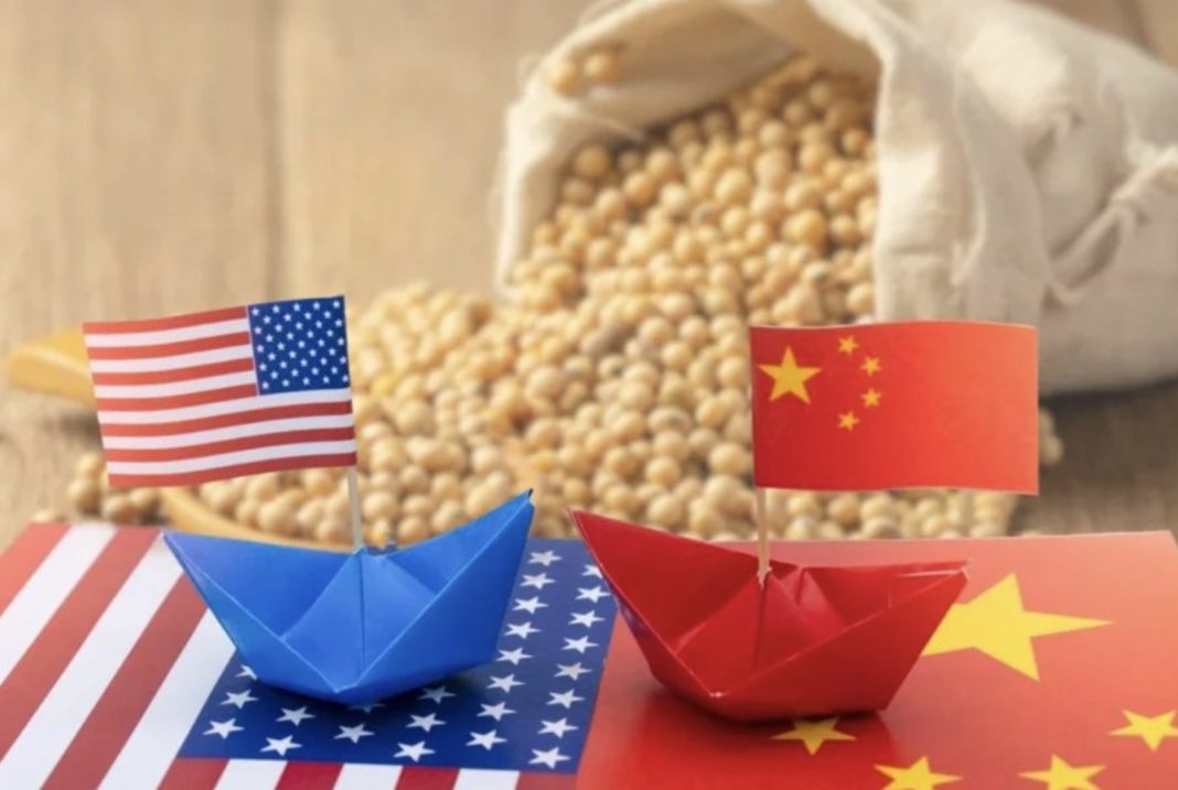 Scene showing US and China flags on a desk with origami paper boats, over star-patterned and striped papers; peanuts spilling from a burlap sack in the background.