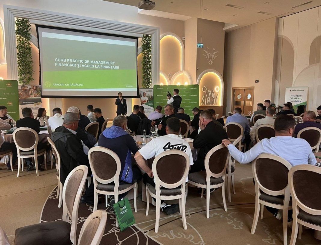Audience seated at round tables in a banquet hall, listening to a presenter on stage with a large screen showing Romanian finance course text: 'CURS PRACTIC DE MANAGEMENT FINANCIAR SI ACCES LA FINANTARE'.