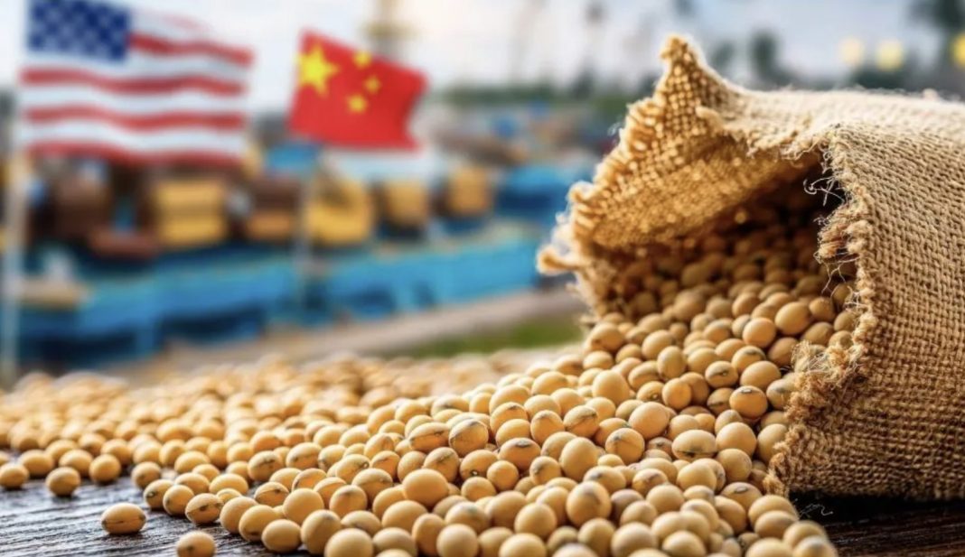 Soybeans spilling from a burlap sack onto a wooden surface, with blurred US and China flags in the background.